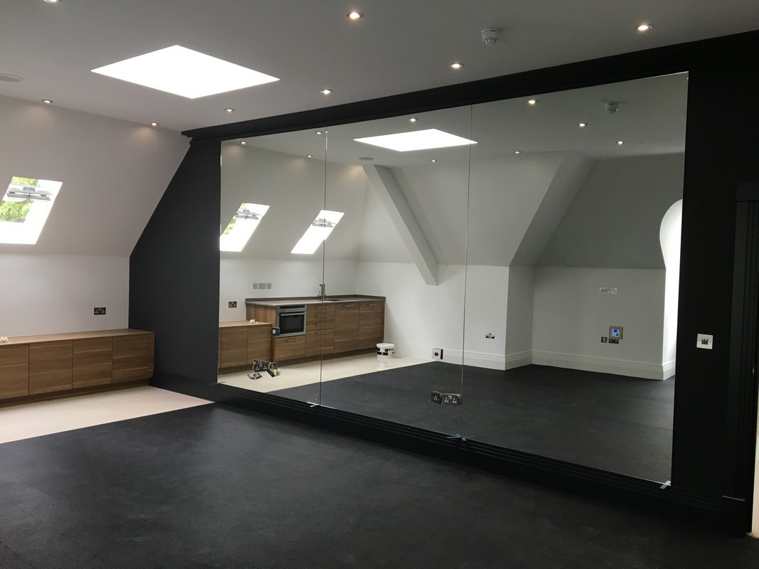 Frameless glass wall dividing loft conversion in Northwood